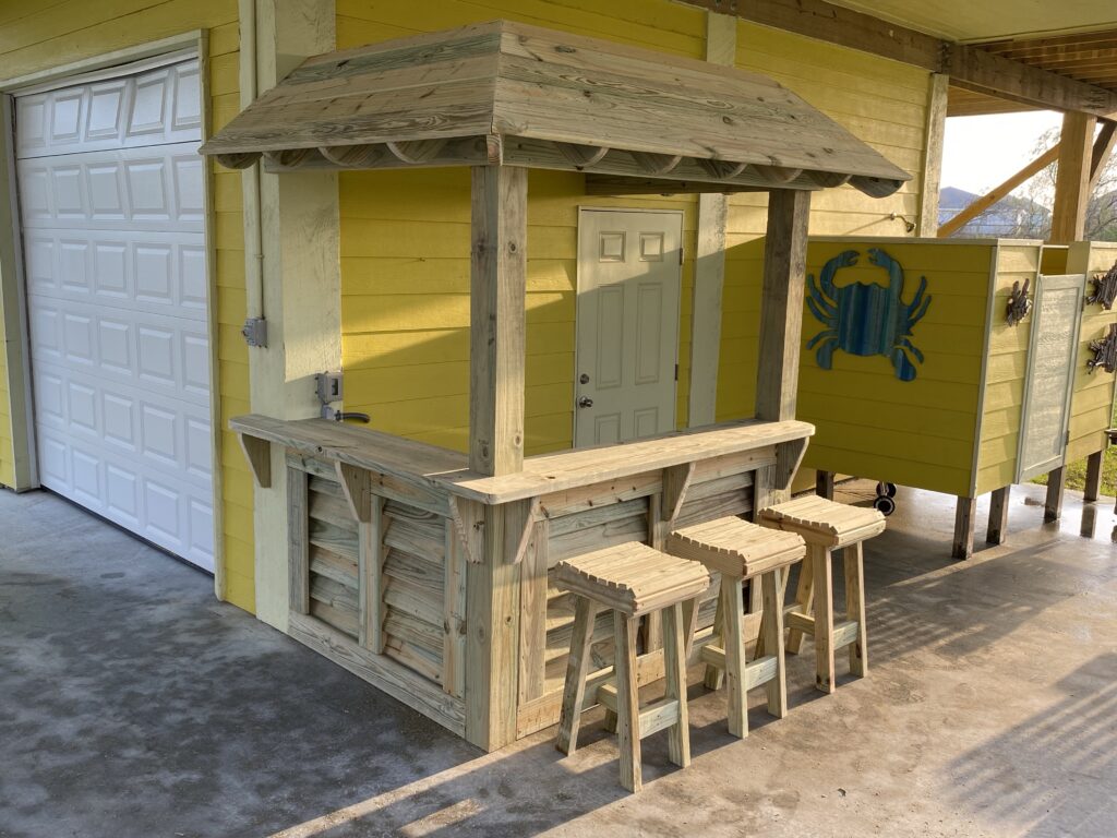 tiki bar with roof and three barstools at garage
